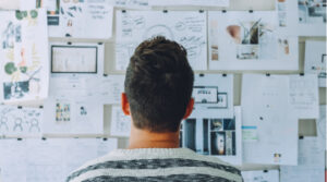 Person looking at board full of ideas, drawings and images Person looking at board full of ideas, drawings and images