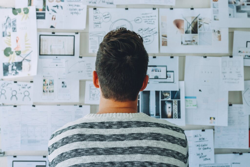 Person from behind looking at work board Person from behind looking at work board